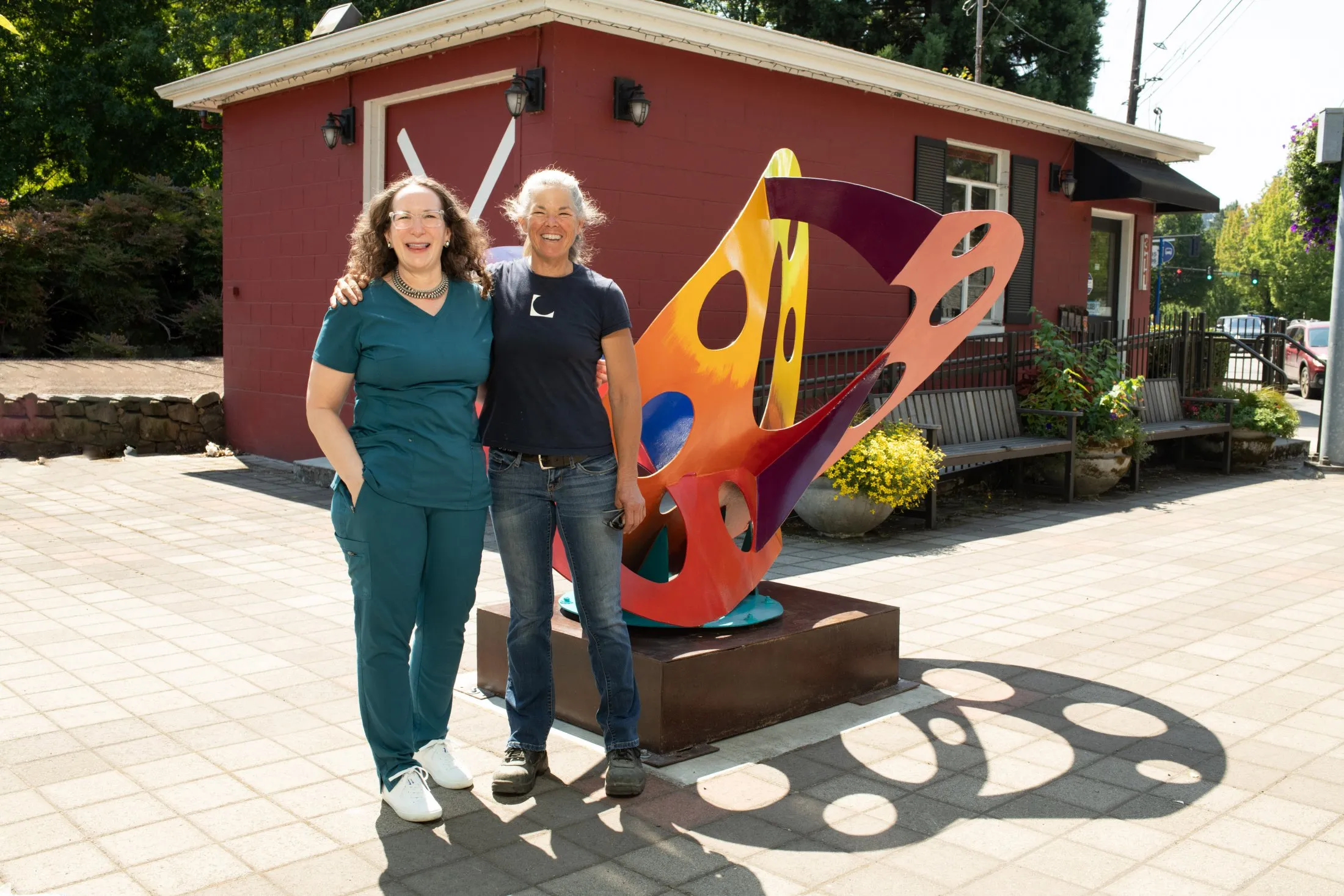 Dr. Geisler with team member standing in front of Gallery Without Walls sculpture